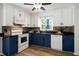 Updated kitchen featuring two-tone cabinets, a mosaic tile backsplash, and stainless steel appliances at 1416 Bramble Dr, Durham, NC 27712