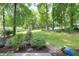 A lush lawn surrounded by mature trees, offering a private and serene outdoor space perfect for relaxation at 1416 Bramble Dr, Durham, NC 27712
