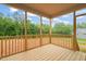 An outdoor wooden back porch featuring views of the wooded yard and blue sky above at 147 Harmony Trl, Broadway, NC 27505