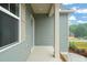 A welcoming front porch with neutral siding, white columns, and a pop of color from nearby roses at 147 Harmony Trl, Broadway, NC 27505