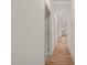 A long hallway featuring hardwood floors and multiple doorways to various rooms at 147 Harmony Trl, Broadway, NC 27505