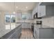 Open kitchen with stainless steel appliances, center island, and gray cabinets at 147 Harmony Trl, Broadway, NC 27505
