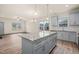 Open-concept kitchen flows into living area with gray cabinets, island, and stainless appliances at 147 Harmony Trl, Broadway, NC 27505
