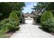 Long driveway leading to a two-car garage, accented by lush greenery at 150 Churchill Rd, Louisburg, NC 27549