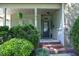 Charming front porch entrance with manicured greenery, stone accents, and brick steps at 150 Churchill Rd, Louisburg, NC 27549