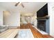 Bright living room featuring hardwood floors, fireplace, and access to the stairs and other rooms at 150 Churchill Rd, Louisburg, NC 27549