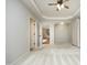 Spacious primary bedroom with tray ceiling, neutral carpet, and doorways to other rooms at 150 Churchill Rd, Louisburg, NC 27549