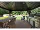 The outdoor kitchen has a built-in grill, ample counter space, and a dining table, making it perfect for entertaining at 150 Churchill Rd, Louisburg, NC 27549
