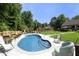 Inviting backyard pool with patio seating and lush green surroundings, perfect for relaxation at 150 Churchill Rd, Louisburg, NC 27549