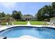 Large backyard pool with patio seating and lush landscaping provides a tranquil escape at 150 Churchill Rd, Louisburg, NC 27549