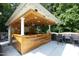 Outdoor bar area with wood paneling, bar seating, and a stylish ceiling fan at 150 Churchill Rd, Louisburg, NC 27549