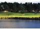Scenic golf course view featuring lush green fairways, a serene lake, and golfers enjoying a round at 1512 Obrien Cir, Wake Forest, NC 27587