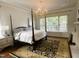 Bright and airy main bedroom featuring a four-poster bed, hardwood floors and natural light at 1512 Obrien Cir, Wake Forest, NC 27587
