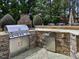 Well-appointed outdoor kitchen with stainless steel appliances, stone countertops, and ample storage at 1512 Obrien Cir, Wake Forest, NC 27587