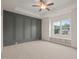Large bedroom featuring carpet, a statement wall, tray ceiling, ceiling fan, and a window bench at 156 Harmony Trl, Broadway, NC 27505