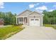 Gray home with a red door, white garage, and a newly laid concrete driveway at 156 Harmony Trl, Broadway, NC 27505