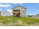 Exterior of the gray home featuring a covered back porch accessible by wooden stairs at 156 Harmony Trl, Broadway, NC 27505