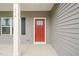 Close-up of a vibrant red front door, featuring a multi-pane window and a sleek, modern design at 156 Harmony Trl, Broadway, NC 27505