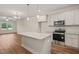 Well-lit kitchen with granite countertops, stainless steel appliances, an island, and adjacent living space at 156 Harmony Trl, Broadway, NC 27505