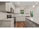 Bright kitchen features white cabinets, granite countertops, stainless steel appliances, and hardwood floors at 156 Harmony Trl, Broadway, NC 27505