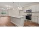 Open concept kitchen boasts an island, granite counters, white cabinets, and stainless steel appliances at 156 Harmony Trl, Broadway, NC 27505