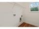The laundry room has wood floors, a window, and connections for a washer and dryer installation at 156 Harmony Trl, Broadway, NC 27505