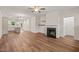 Open-concept layout with hardwood floors, a fireplace, and a view into the modern kitchen at 156 Harmony Trl, Broadway, NC 27505