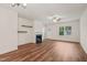 Spacious living room featuring a fireplace, ceiling fan, and warm, inviting hardwood floors at 156 Harmony Trl, Broadway, NC 27505