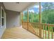 Covered porch featuring a light wood floor and railing offering scenic views of the property's trees at 156 Harmony Trl, Broadway, NC 27505