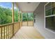 The covered porch has wood floors and railing, offering a great view of the surrounding trees at 156 Harmony Trl, Broadway, NC 27505