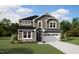 Charming two-story home with stone accents, a well-manicured lawn, and a two car garage at 164 Sprenger St, Garner, NC 27529