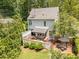 Aerial view of the home's back exterior, deck with awning, patio, and the surrounding lush greenery at 1901 White Oak Rd, Raleigh, NC 27608