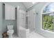 Bathroom featuring skylight, glass shower, marble floors and a large window at 1901 White Oak Rd, Raleigh, NC 27608