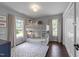 Bright bedroom with a white bunk bed, large windows, and a patterned rug at 1901 White Oak Rd, Raleigh, NC 27608