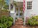Inviting front porch with brick steps, potted plants, and an American flag creating a warm welcome at 1901 White Oak Rd, Raleigh, NC 27608