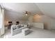 Cozy attic living room with white paneling, modern furniture, and a ceiling fan at 1901 White Oak Rd, Raleigh, NC 27608