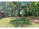 Large, green backyard with mature trees, open space, and a shed, perfect for outdoor activities and storage at 2005 Messer Rd, Raleigh, NC 27603