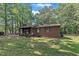 Cozy brick home with a covered front porch and well-maintained lawn, showcasing classic design at 2005 Messer Rd, Raleigh, NC 27603