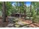 Charming brick home with a cozy front porch, surrounded by mature trees and natural landscaping at 2005 Messer Rd, Raleigh, NC 27603