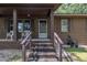 Inviting front porch with brick steps and classic columns, offering a cozy welcome to this brick home at 2005 Messer Rd, Raleigh, NC 27603