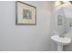 Charming powder room features pedestal sink, oval mirror, and decorative wall art at 2021 Rivergate Rd # 102, Raleigh, NC 27614