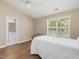 Cozy bedroom features wood floors, neutral paint, ceiling fan, and lots of natural light from the large window at 2021 Rivergate Rd # 102, Raleigh, NC 27614