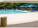 Community pool with many lounge chairs and blue umbrellas provides a relaxing neighborhood spot at 2021 Rivergate Rd # 102, Raleigh, NC 27614