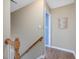 Neutral hallway featuring wood railing, baseboards and door leading to another room at 2021 Rivergate Rd # 102, Raleigh, NC 27614