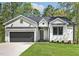 Charming home showcasing vertical siding, a two-car garage, and a well-manicured lawn at 205 Shawnee Dr, Louisburg, NC 27549