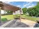 Back deck with seating beneath a pergola overlooking the expansive, verdant backyard at 2108 Carthage Cir, Raleigh, NC 27604