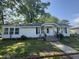 Charming single-story home featuring a well-maintained yard, cozy porch, and lovely curb appeal on a sunny day at 212 S Sixth St, Smithfield, NC 27577