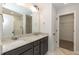 Bathroom featuring double sink, granite countertops, a large mirror, and a walk in closet at 213 Clement Ave, Oxford, NC 27565