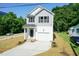 Charming two-story home with gray and white siding, front porch, and a concrete driveway leading to an attached garage at 213 Clement Ave, Oxford, NC 27565
