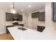 Well-equipped kitchen with gray cabinets, stainless steel appliances, and a spacious island with white countertops at 213 Clement Ave, Oxford, NC 27565
